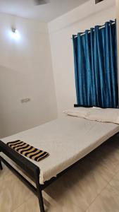 uma cama num quarto com uma cortina azul em LMR Stays and Holidays em Thrissur