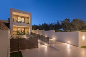 a modern house with a fence and lights at Anantia Luxury Maisonette - Scenic View in episkopi-heraklion