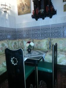 sala de estar con sofá, mesa y silla en Ryad Meknassia, en Meknès