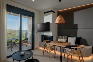 a living room with a table and chairs and a tv at Anantia Luxury Maisonette - Scenic View in Episkopi (Heraklion)