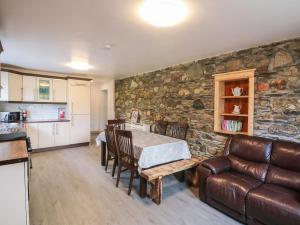 a kitchen and living room with a table and a couch at Curragh Cottage 