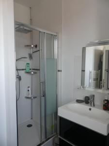 Un baño con ducha de cristal y lavabo. en Comme chez vous, en Le Crotoy 13 fotos más