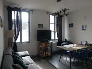 a living room with a couch and a table at Comme chez vous in Le Crotoy