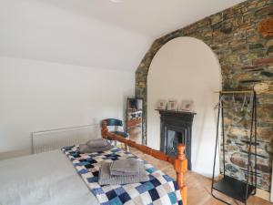 a bedroom with a bed and a fireplace at Curragh Cottage 