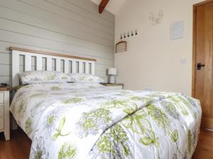 a bedroom with a bed with a green and white comforter at The Piggery in Penzance