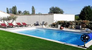 einen Pool in einem Garten mit Stühlen und einem Haus in der Unterkunft CHAMBRE D'HÔTES "Le petit Valadas" à 7km d'UZES in Serviers-et-Labaume