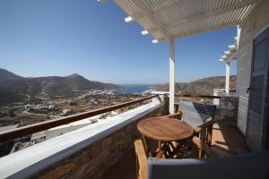 a balcony with a table and chairs and a view at Skopelitis Village in Katapola