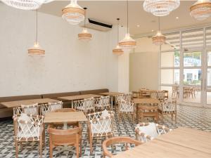 uma sala de jantar com mesas, cadeiras e lustres em Ciela Hotel & Beach Club em Coveñas