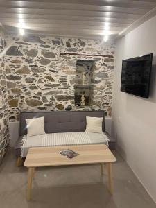 een kamer met een bank en een stenen muur bij Artdecosyros Junior in Ano Syros
