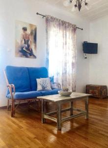 a living room with a blue couch and a table at Spacious Apartment with Sea View in Tzamarelata - 90 m² in Tzamarelláta
