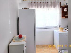 um frigorífico branco numa cozinha com uma janela em 3 bedrooms apartement with city view and wifi at Amora 8 km away from the beach em Amora