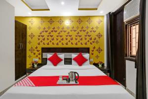 ein Schlafzimmer mit einem großen weißen Bett mit roten Kissen in der Unterkunft OYO Flagship Hotel Blue Orchid in Neu-Delhi