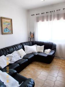 a black leather couch in a living room with a window at 3 bedrooms apartement with city view and wifi at Amora 8 km away from the beach in Amora