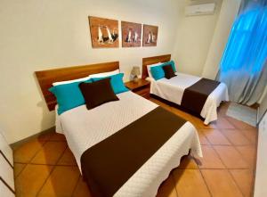 a bedroom with two beds with blue and black at Torre Mar Galapagos Boutique Suites in Puerto Ayora