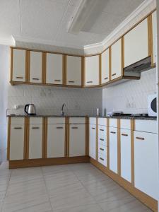 - une cuisine avec des placards en bois et des appareils blancs dans l'établissement ALCANAR DEL MAR, à Les Cases d'Alcanar