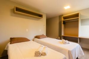 two beds in a room with towels on them at Casas Refúgio da Barra in Barra Grande +73 photos