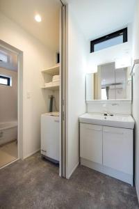 a white bathroom with a sink and a mirror at Aile Hose Ⅱ in Takasaki