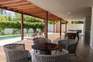 a patio with chairs and tables and a pool at Casas Refúgio da Barra in Barra Grande