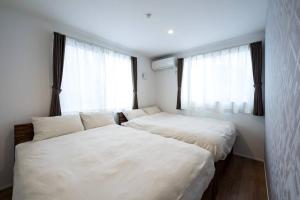 two beds in a room with two large windows at Aile Hose Ⅱ in Takasaki +31 photos