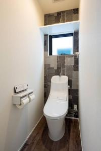 a bathroom with a toilet in a room with a window at Aile Hose Ⅱ in Takasaki