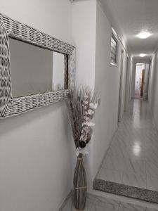 un vase avec des fleurs dans un couloir avec un miroir dans l'établissement ALCANAR DEL MAR, à Les Cases d'Alcanar