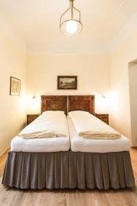 a bedroom with a large bed with a wooden headboard at Villa Thalhof in Bad Gleichenberg