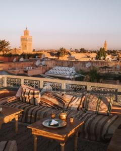 a patio with a couch and tables on a roof at Riad Ksar Fawz & Spa in Marrakech