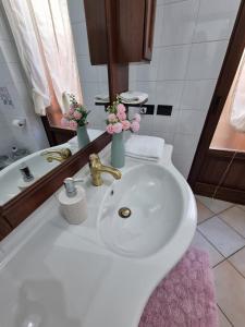 ein Badezimmer mit einem weißen Waschbecken und einem Spiegel in der Unterkunft MAREMONTI Poggio Dei Pini Capoterra in Capoterra