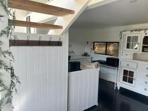 a kitchen with white cabinets and a window at Paisanas Wisemans Ferry in Wisemans Ferry
