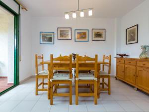 una sala da pranzo con tavolo e sedie di Apartamento luminoso con jardín, piscina comunitaria y cerca de la playa en Llançà. - ES-228-41 a Llança