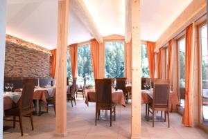 a dining room with tables and chairs and windows at Hotel Romantica in Samnaun