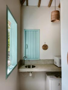 eine Küche mit einem Waschbecken und einem Spiegel in der Unterkunft Pousada Refazenda in Corumbau
