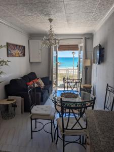 レス・カセス・ダルカナールにあるALCANAR DEL MARのガラスのテーブルと椅子のあるリビングルーム