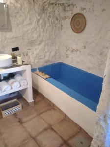 baño con bañera azul en una pared de piedra en COVES DEl XUQUER, en Jorquera