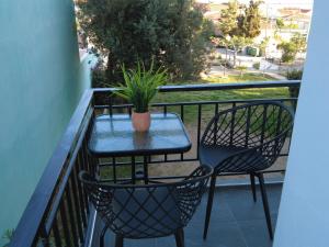 a table and chairs on a balcony with a potted plant at Dimitras apartment in Paleo Tsifliki