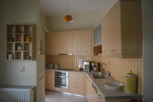 a kitchen with white cabinets and a sink and stove at Amarillo Apt. Nafplio Downtown in Nafplio