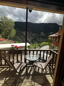 a patio with a table and chairs on a balcony at Via Ferrata Hotel in Prousós