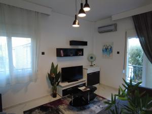 a living room with a tv and a desk at Dimitras apartment in Paleo Tsifliki