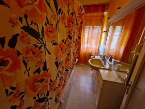 een badkamer met 2 wastafels en een bloemenmand bij Maremma Nel Tufo Centro in Pitigliano