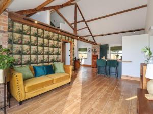 un soggiorno con divano giallo di Nell's Cottage a Malton