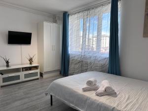 a bedroom with a bed and a large window at Diamant residence - self check in & free parking in Bragadiru