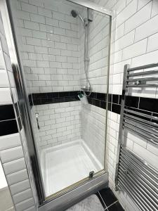 a shower with a glass door in a bathroom at Lovely 5BR Home in Manchester. Close to the City in Manchester