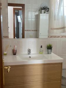 ein Bad mit einem Waschbecken und einem Spiegel in der Unterkunft Sun&Relax Apto 2dormitorios 6-7pWifi&Piscina in Puerto de Santiago
