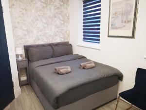 a bedroom with a bed with two towels on it at Stylish Studio minutes away from Wembley in London