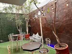 un patio avec des chaises, des tables et un arbre dans l'établissement Hotel del Fresno, à Fresnillo de González Echeverría