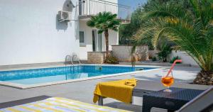 a drink on a table next to a swimming pool at Villa Patricija in Medulin