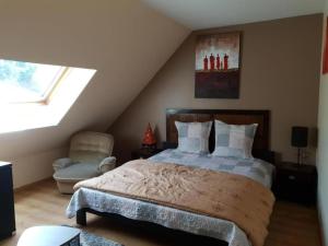 ein Schlafzimmer mit einem Bett und einem Stuhl im Dachgeschoss in der Unterkunft Suite 2 chambres Salle de bain privée Terrasse 30min PARIS in Corbeil-Essonnes