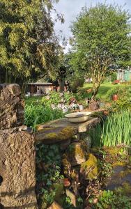 a stone bench in the middle of a garden at Le grivé in Chèvremont