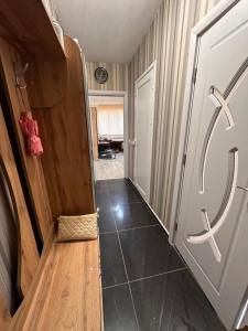 un couloir avec une porte en bois et un sol carrelé dans l'établissement Апартамент Lotus, à Varna