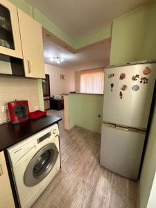 une cuisine avec un réfrigérateur et une machine à laver dans l'établissement Апартамент Lotus, à Varna